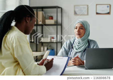Looking at patient signing document Looking at patient signing document 116808678