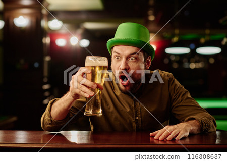 Surprised man looking at glass of beer 116808687