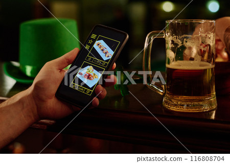 Man with beer choosing sushi rolls 116808704