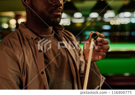 Rubbing billiard cue tip before game 116808775