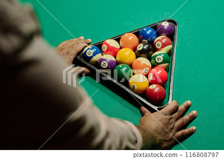 Man touching triangular rack with balls Man touching triangular rack with balls 116808797