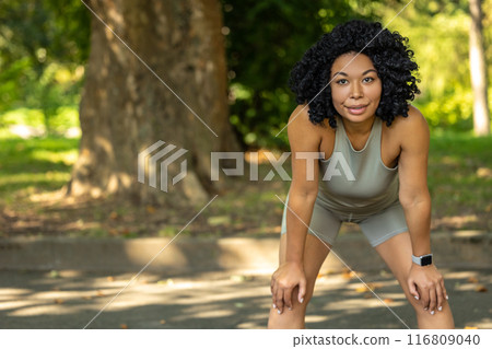 Woman exercising in a park and having a short pause 116809040