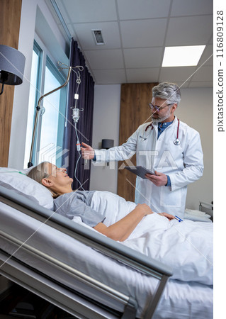 Doctor checking a IV drip in an intensive therapy department and looking concerned 116809128