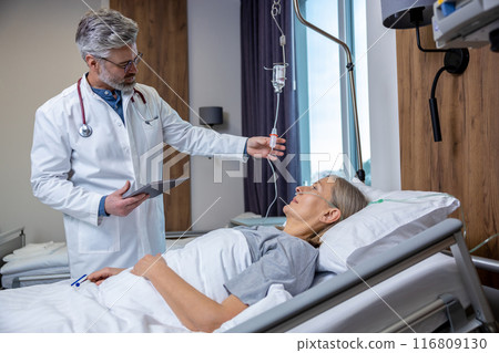 Doctor checking a IV drip in an intensive therapy department and looking concerned 116809130