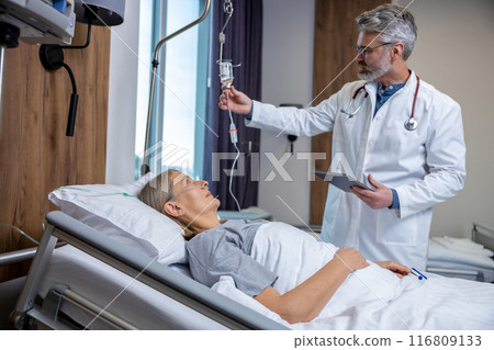 Doctor checking a IV drip in an intensive therapy department and looking concerned 116809133