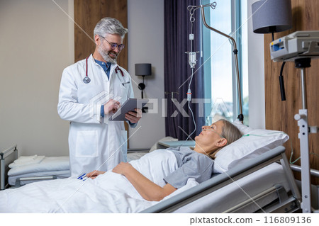 Doctor checking a IV drip in an intensive therapy department and looking concerned 116809136