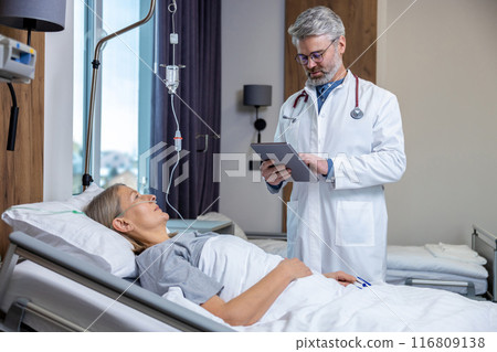 Doctor making a list of prescriptions to a patient in an intensive therapy department 116809138