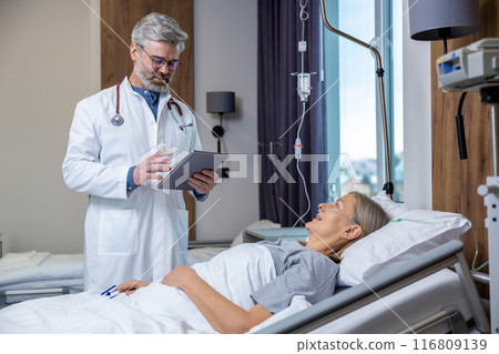 Doctor making a list of prescriptions to a patient in an intensive therapy department 116809139