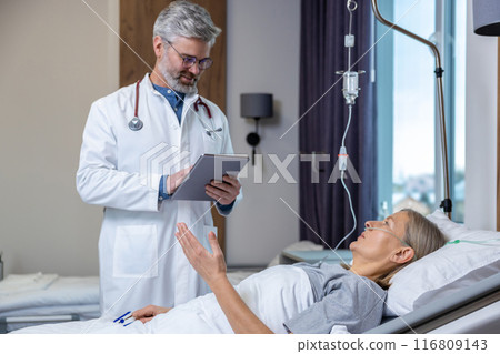 Doctor making a list of prescriptions to a patient in an intensive therapy department Doctor making a list of prescriptions to a patient in an intensive therapy department 116809143