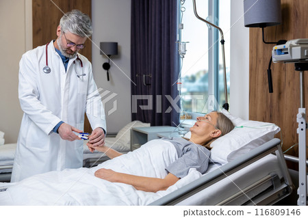 Doctor making a list of prescriptions to a patient in an intensive therapy department 116809146