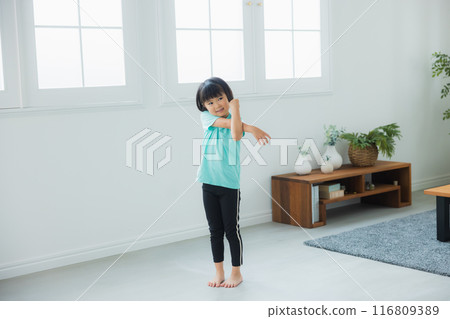 A child stretching in the living room A child stretching in the living room 116809389