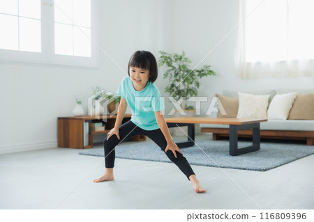 A child stretching in the living room 116809396