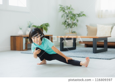 A child stretching in the living room 116809397