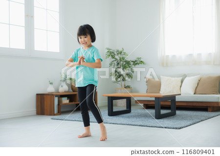 A child stretching in the living room 116809401