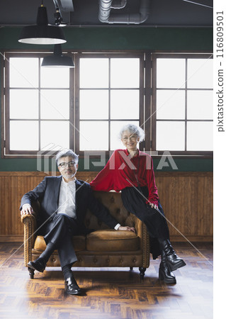 Grey-haired couple sitting on a sofa Grey-haired couple sitting on a sofa 116809501