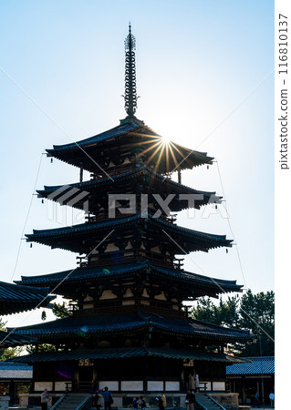 [Nara Prefecture] The five-story pagoda of Horyuji Temple silhouetted against the backlight 116810137