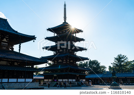 [Nara Prefecture] The five-story pagoda of Horyuji Temple silhouetted against the backlight 116810140