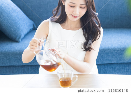 Woman drinking tea in the room Woman drinking tea in the room 116810148