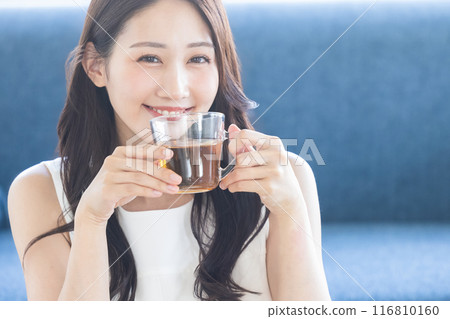 Woman drinking tea in the room Woman drinking tea in the room 116810160