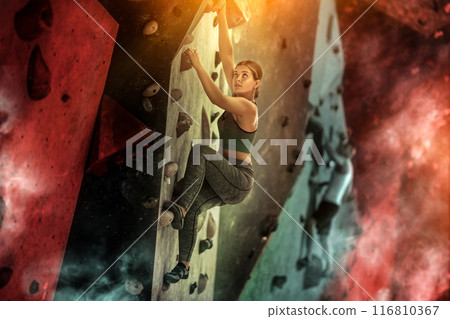 Sporty woman training at bouldering gym without special climbing equipment 116810367