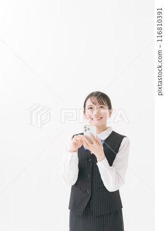 A smiling woman in uniform holding a smartphone A smiling woman in uniform holding a smartphone 116810391