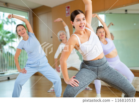 Active young woman practicing aerobic dance in training hall 116810533