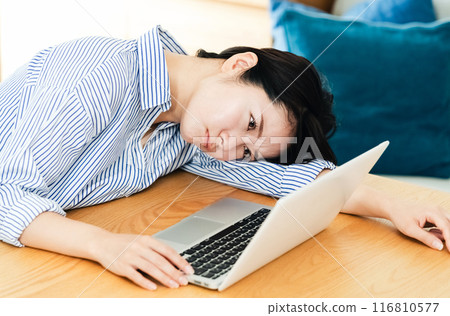 Young woman using a computer in the living room 116810577