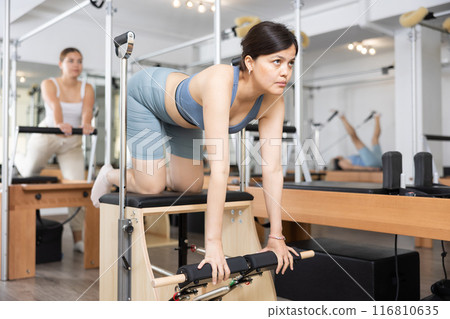 Young asian woman practicing pilates on wunda chair 116810635