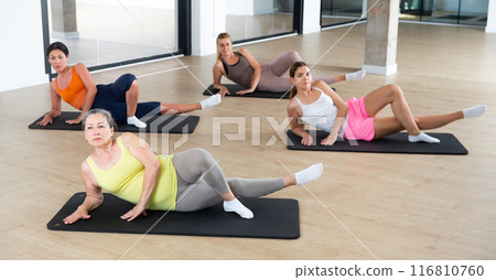 Women doing fitness exercises on mats 116810760