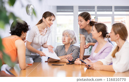 Young woman friendly talking to female colleagues in office 116810770