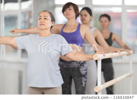 Elderly woman standing in second position in beginner ballet class Elderly woman standing in second position in beginner ballet class 116810847
