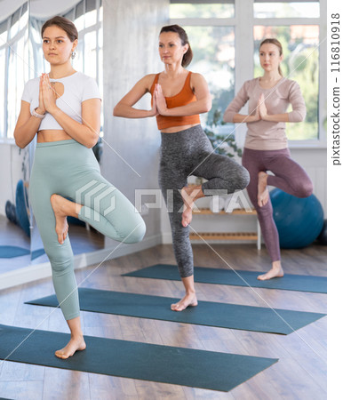 Group of women doing yoga in studio Group of women doing yoga in studio 116810918