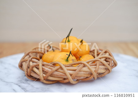 Fresh tangerines in a basket, stock photo Fresh tangerines in a basket, stock photo 116810951