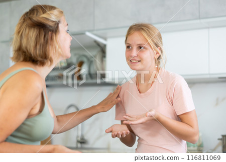 Teenage daughter enthusiastically tells unrecognizable mother about planned vacation with friends Teenage daughter enthusiastically tells unrecognizable mother about planned vacation with friends 116811069