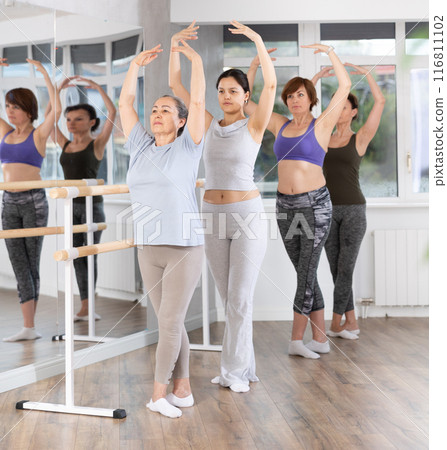 Senior woman performing fifth ballet position during amateur workout 116811102