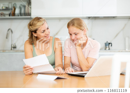 Joyful and overjoyed mother and teenager daughter reads letter and learn good news Joyful and overjoyed mother and teenager daughter reads letter and learn good news 116811119