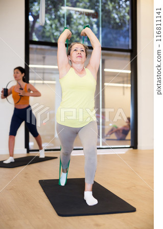 Woman are doing stretching exercise with green resistance bands 116811141