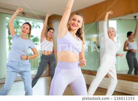 Active middle-aged woman practicing aerobic dance in training hall 116811155