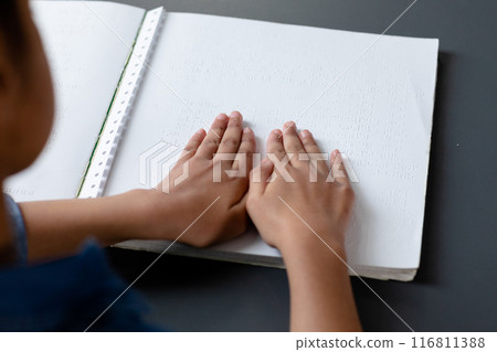 Hands of biracial schoolgirl reading braille book in school class, with copy space Hands of biracial schoolgirl reading braille book in school class, with copy space 116811388