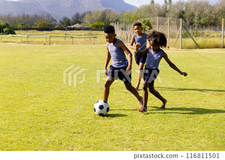 Happy african american schoolchildren playing football on field at school 116811501