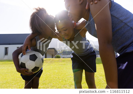 Happy african american schoolchildren playing football on field at school Happy african american schoolchildren playing football on field at school 116811512