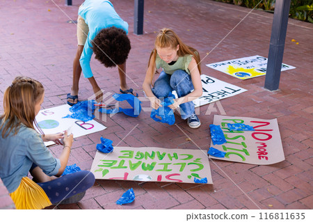 Happy diverse schoolchildren making ecology posters during outdoor school art class Happy diverse schoolchildren making ecology posters during outdoor school art class 116811635