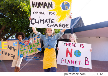 Happy diverse schoolchildren holding ecology posters made in art class outside school Happy diverse schoolchildren holding ecology posters made in art class outside school 116811649