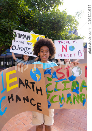 Happy diverse schoolchildren holding ecology posters made in art class outside school Happy diverse schoolchildren holding ecology posters made in art class outside school 116811655