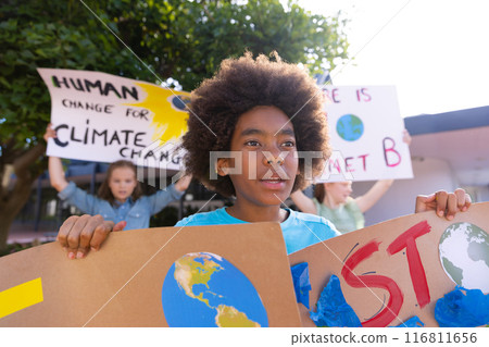 Happy diverse schoolchildren holding ecology posters made in art class outside school Happy diverse schoolchildren holding ecology posters made in art class outside school 116811656