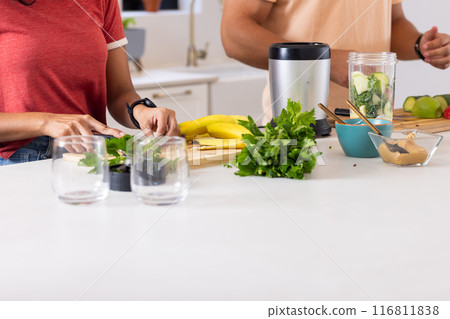 Preparing healthy smoothie, couple chopping vegetables and fruits in kitchen 116811838