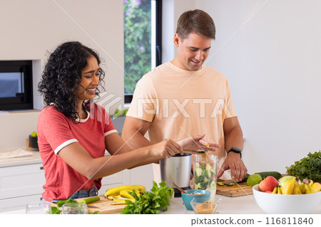 Preparing healthy smoothie, young couple chopping fruits in kitchen Preparing healthy smoothie, young couple chopping fruits in kitchen 116811840