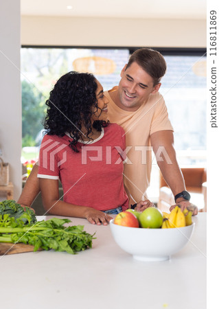 Smiling young couple preparing healthy meal with fresh vegetables in kitchen 116811869