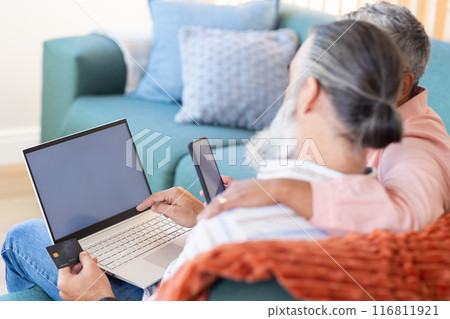Senior couple using laptop and smartphone for online shopping with credit card, copy space Senior couple using laptop and smartphone for online shopping with credit card, copy space 116811921