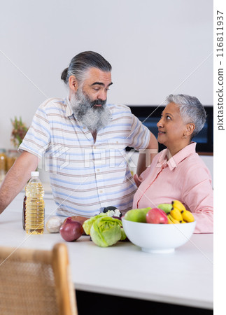 Senior couple in kitchen, preparing healthy meal with fresh vegetables and fruits 116811937